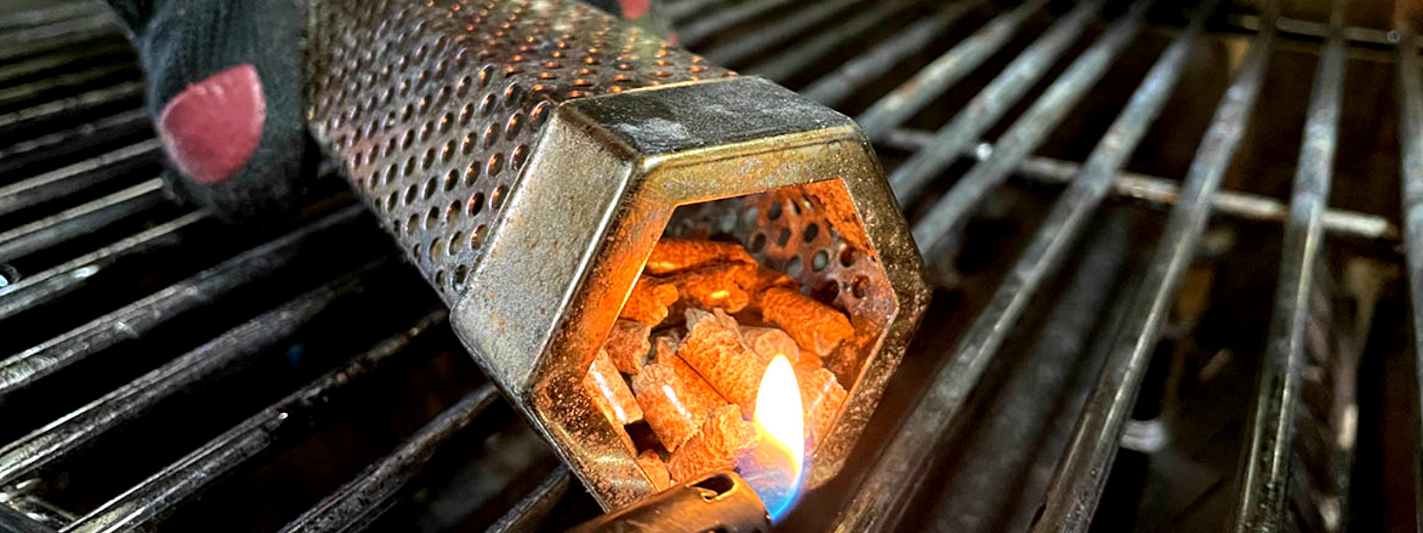 A imagem mostra serragem sendo acesa em uma caixa de defumação a frio