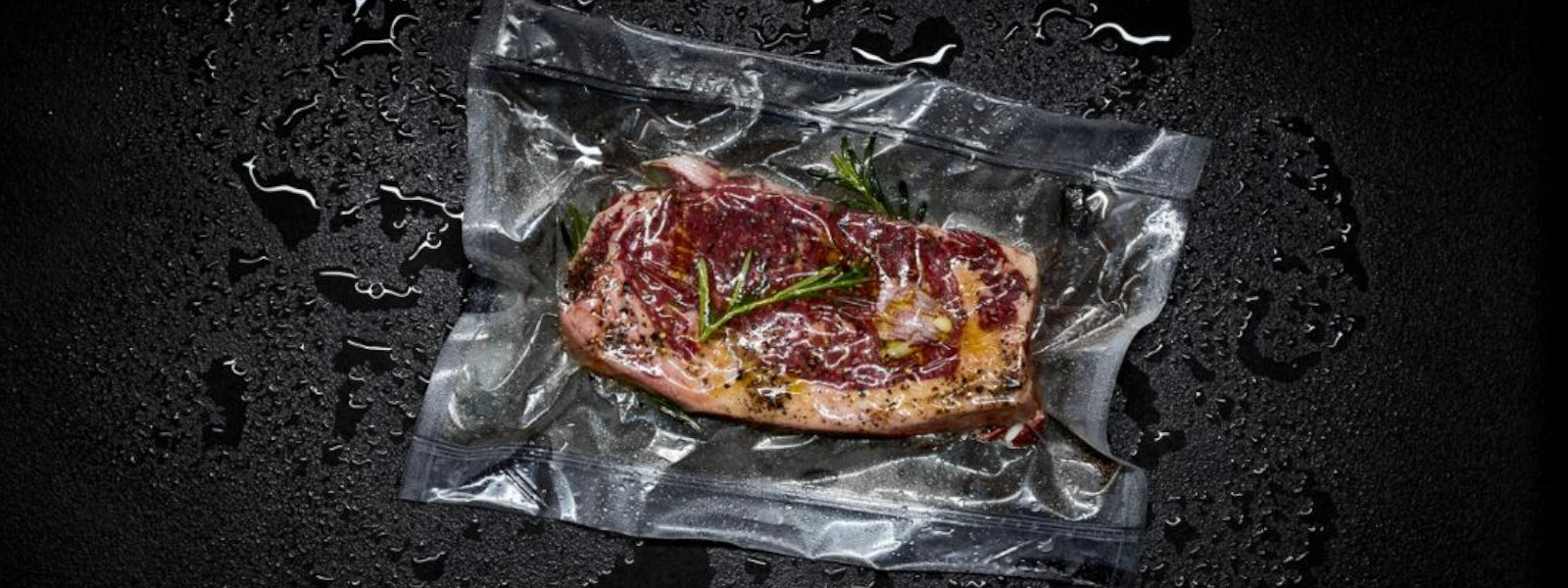 A imagem mostra um steak embalado à vácuo com algumas ervas