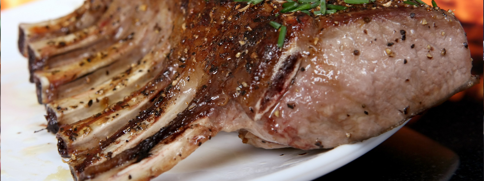 A imagem mostra um rack de costelas suínas grelhadas.