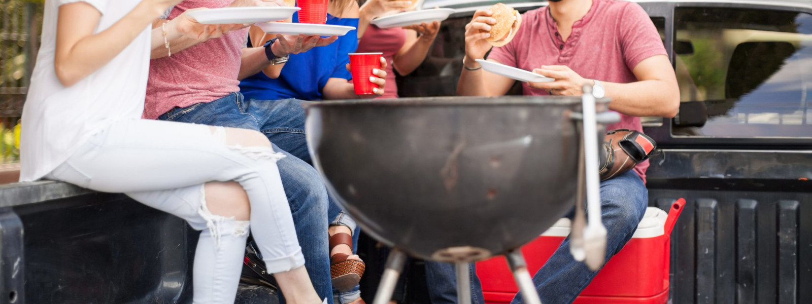 A imagem mostra um churrasco para 30 pessoas com convidados ao redos da churrasqueira