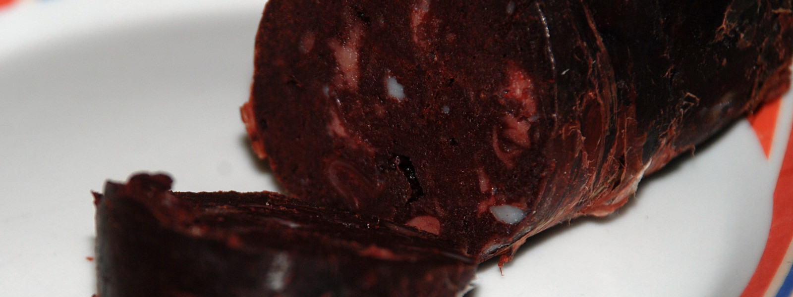 A imagem mostra uma linguiça de sangue fatiada.