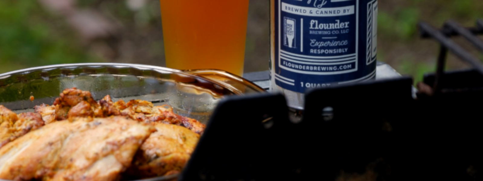 A imagem mostra um copo de cerveja e frango durante um churrasco de frango na cerveja