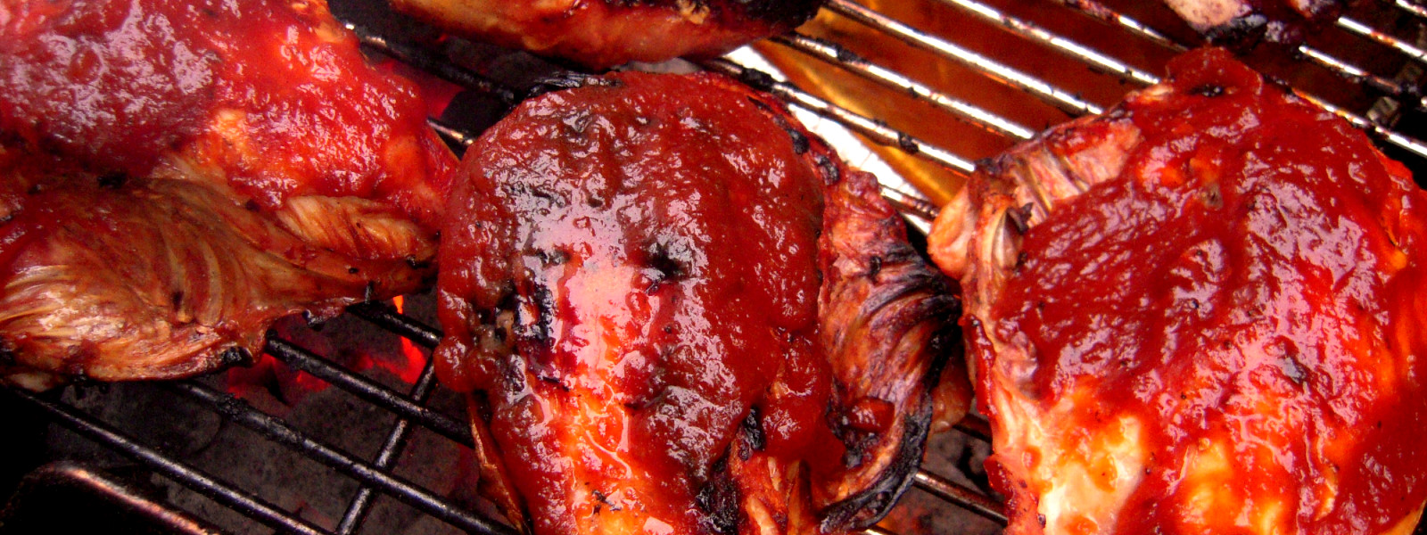 A imagem mostra uma churrasqueira fazendo churrasco de frango