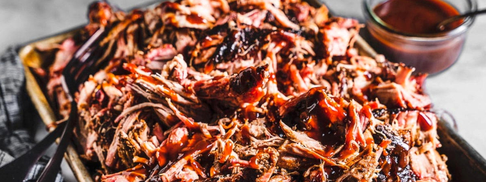 A imagem mostra um prato de pulled pork no forno