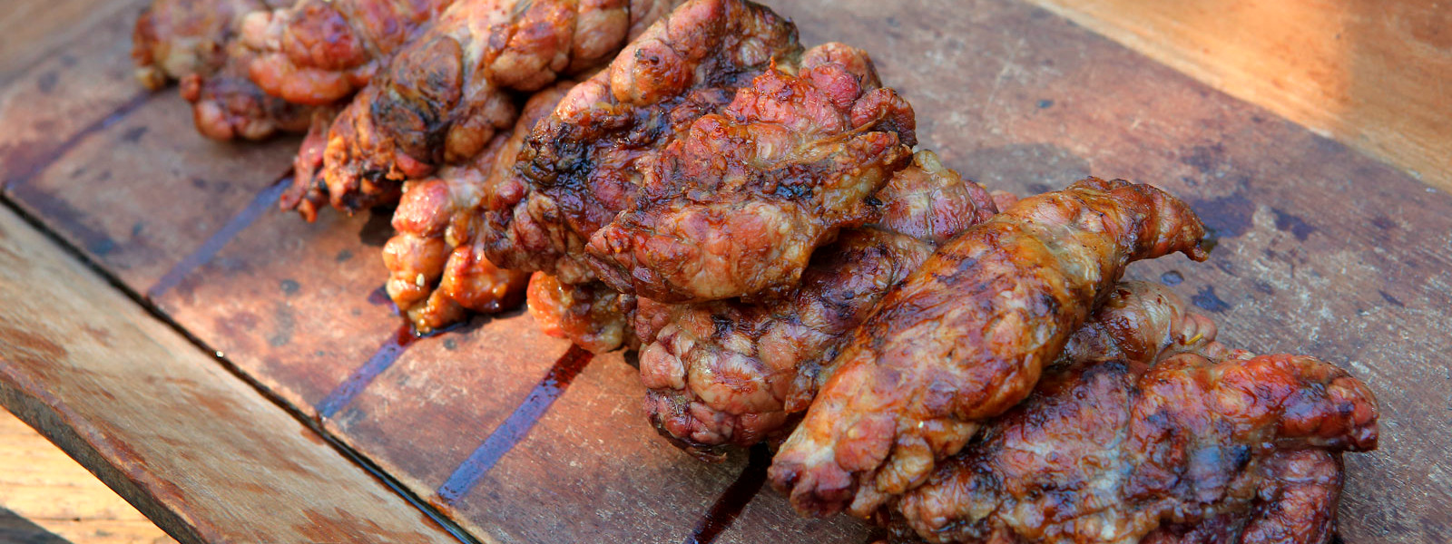 A imagem mostra uma tábua de corte com mollejas grelhadas em cima