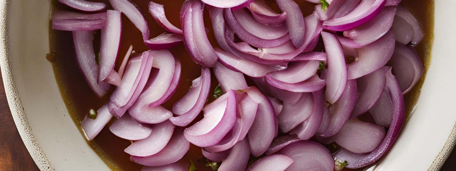 A imagem mostra uma travessa contendo vinagrete de cebola roxa