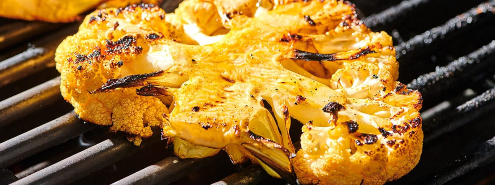 A imgem mostra um bife de couve flor na churrasqueira