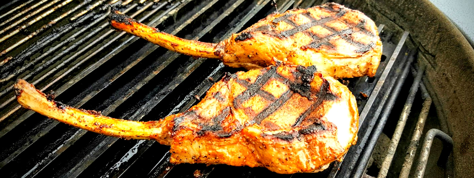 A imagem mostra carne suína para churrasco sendo preparada na brasa